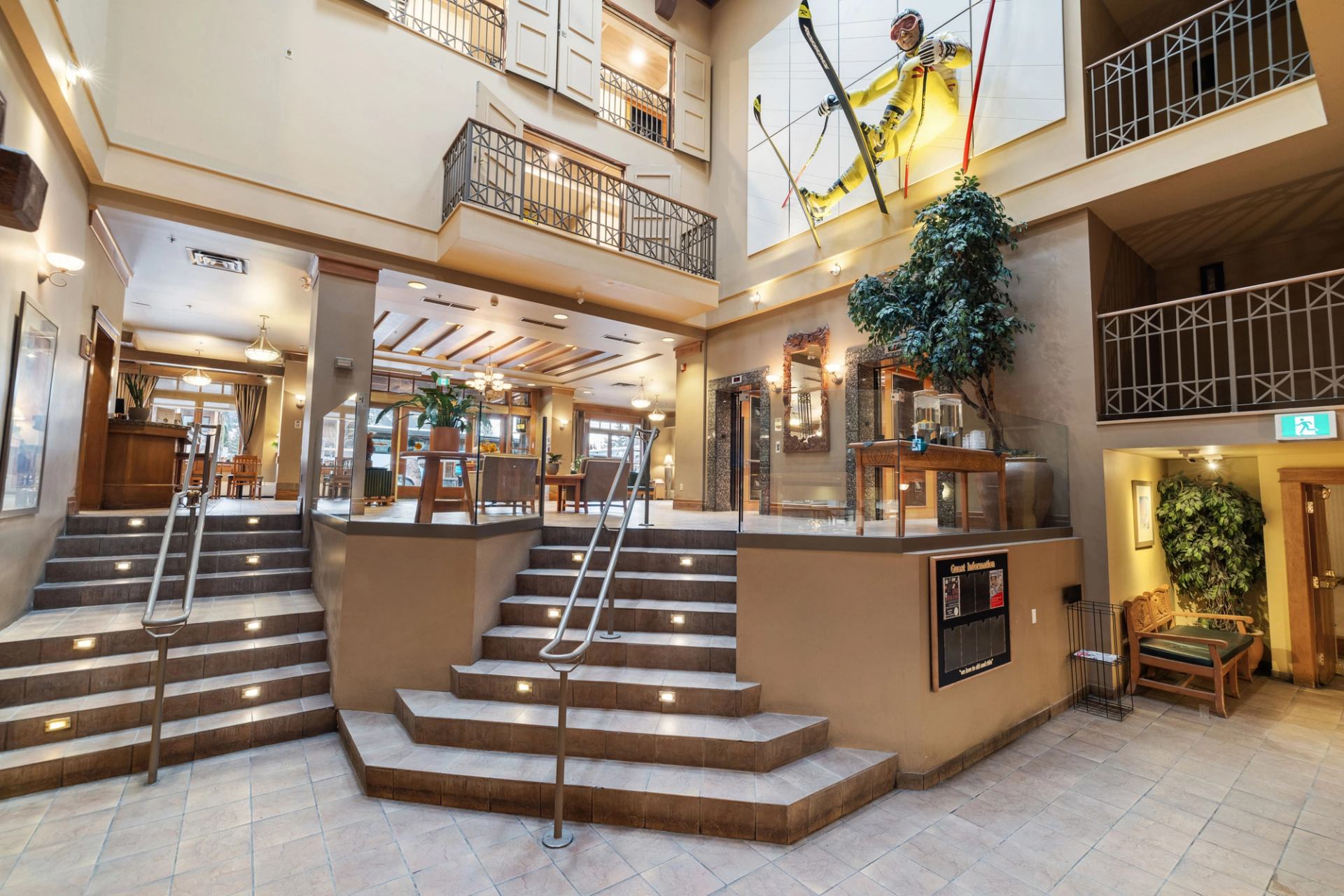 Atrium with wood accents, balconies, a large skier statue, and seating at Banff Ptarmigan Inn.