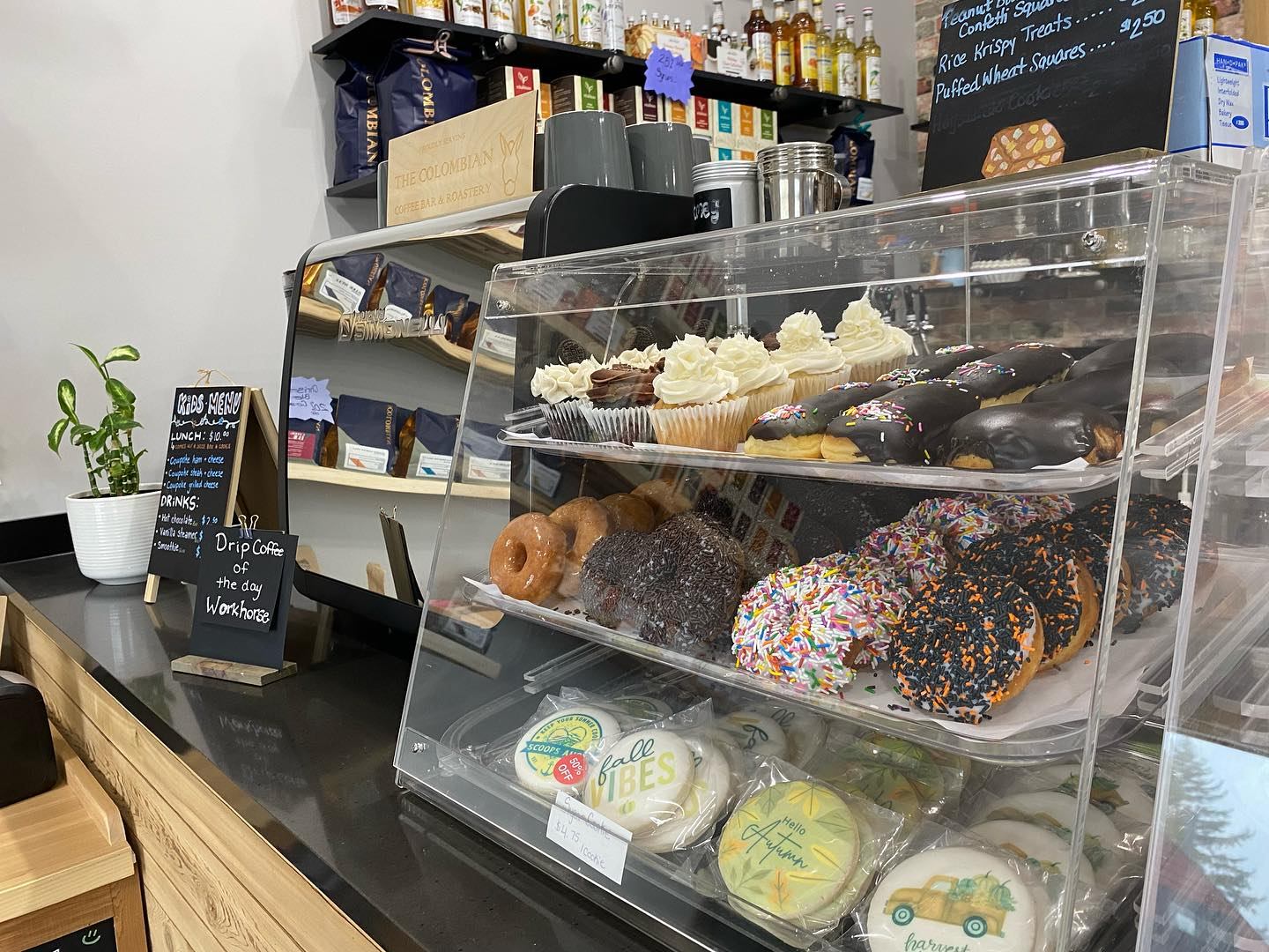 Display case with pastries, menu signs, and shelves of goods inside Farmstead Market & More Bistro.
