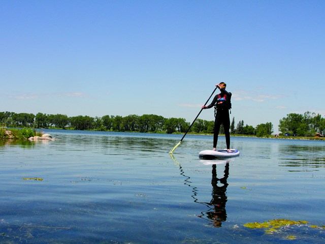 A person stand up paddling boarding on the lake