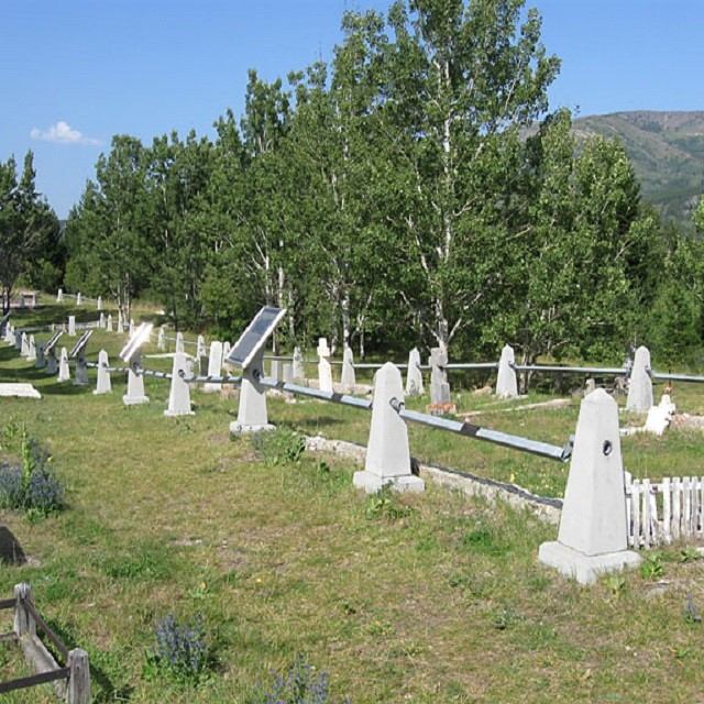 White tombstones in Hillcrest Cemetery, surrounded by grass and trees, marking a historic mining tragedy.