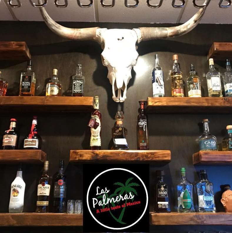 Liquor shelf with bull skull and Las Palmeras sign at the bar.