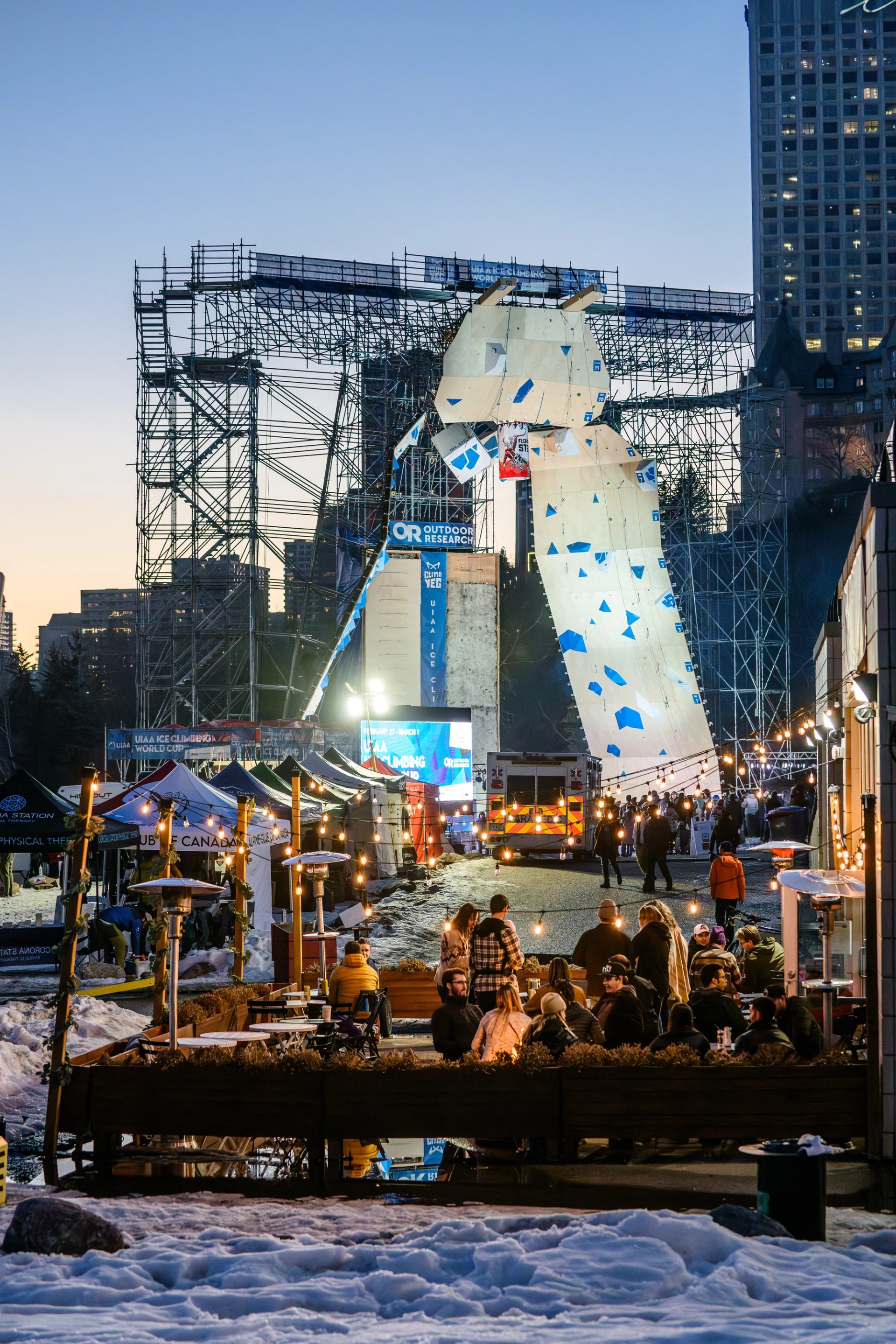 Outdoor climbing wall at Climb YEG lit up during an evening event.