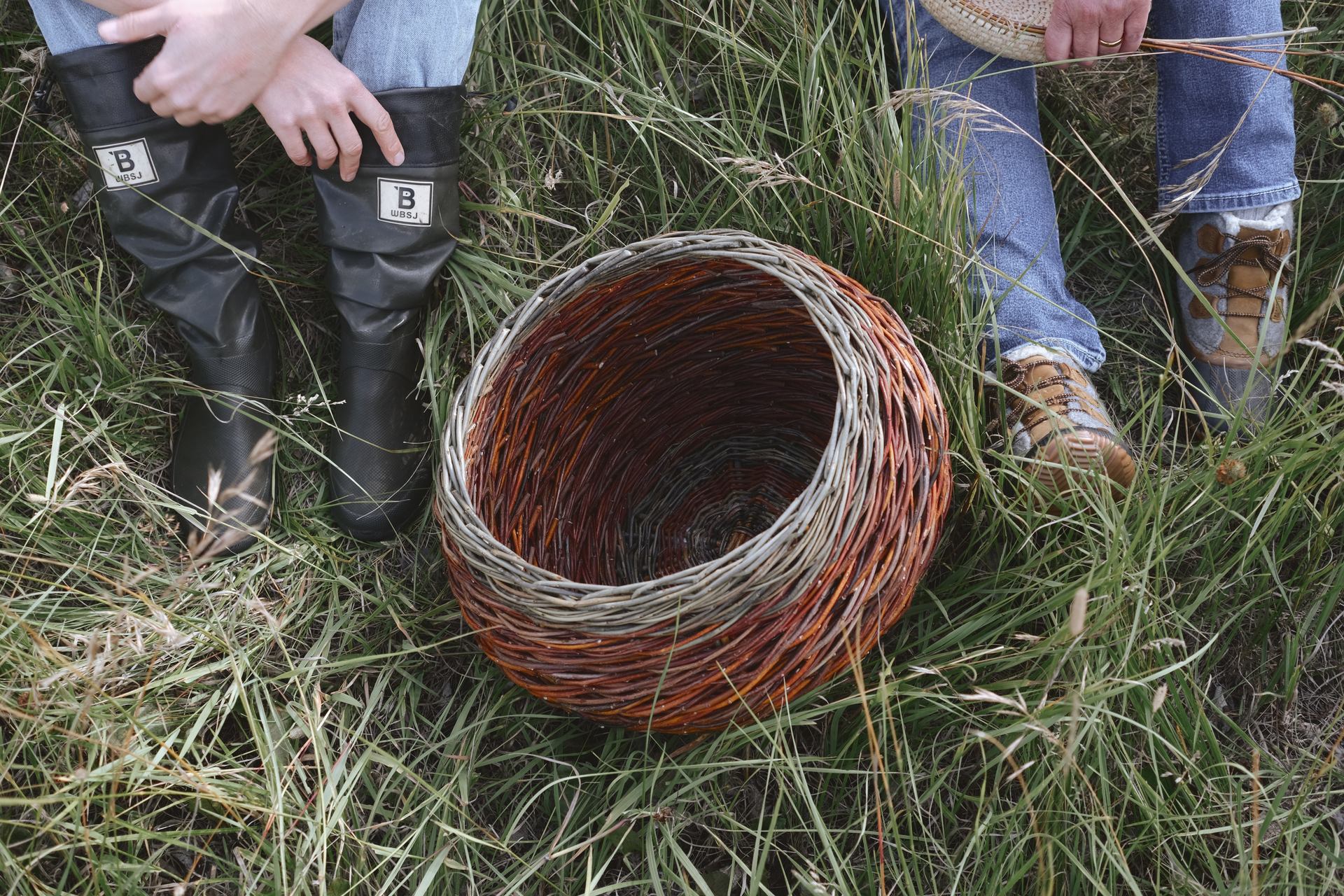 Long grass, a basket, and some feet with sturdy footwear.