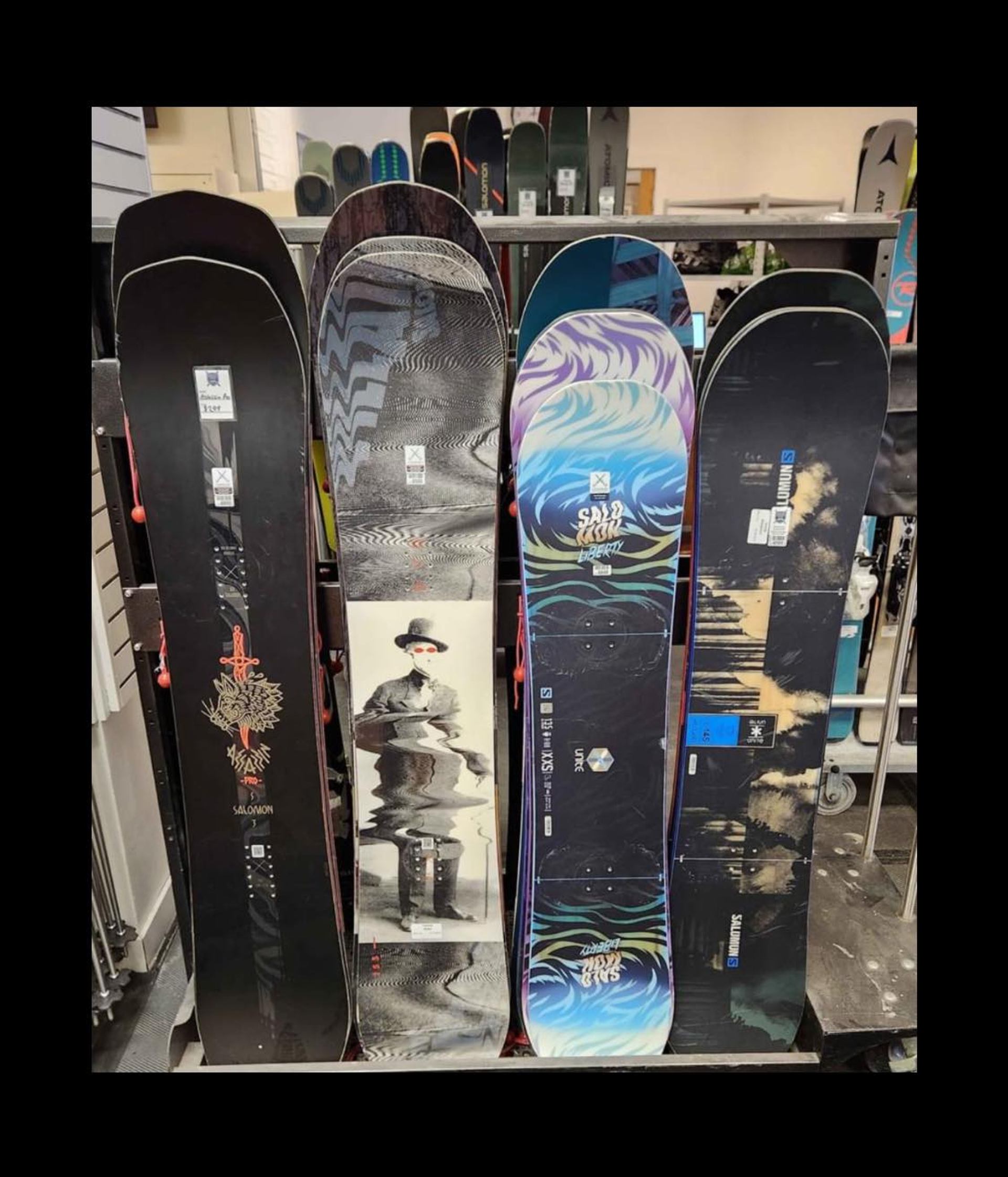 Four colorful snowboards standing upright in a shop display