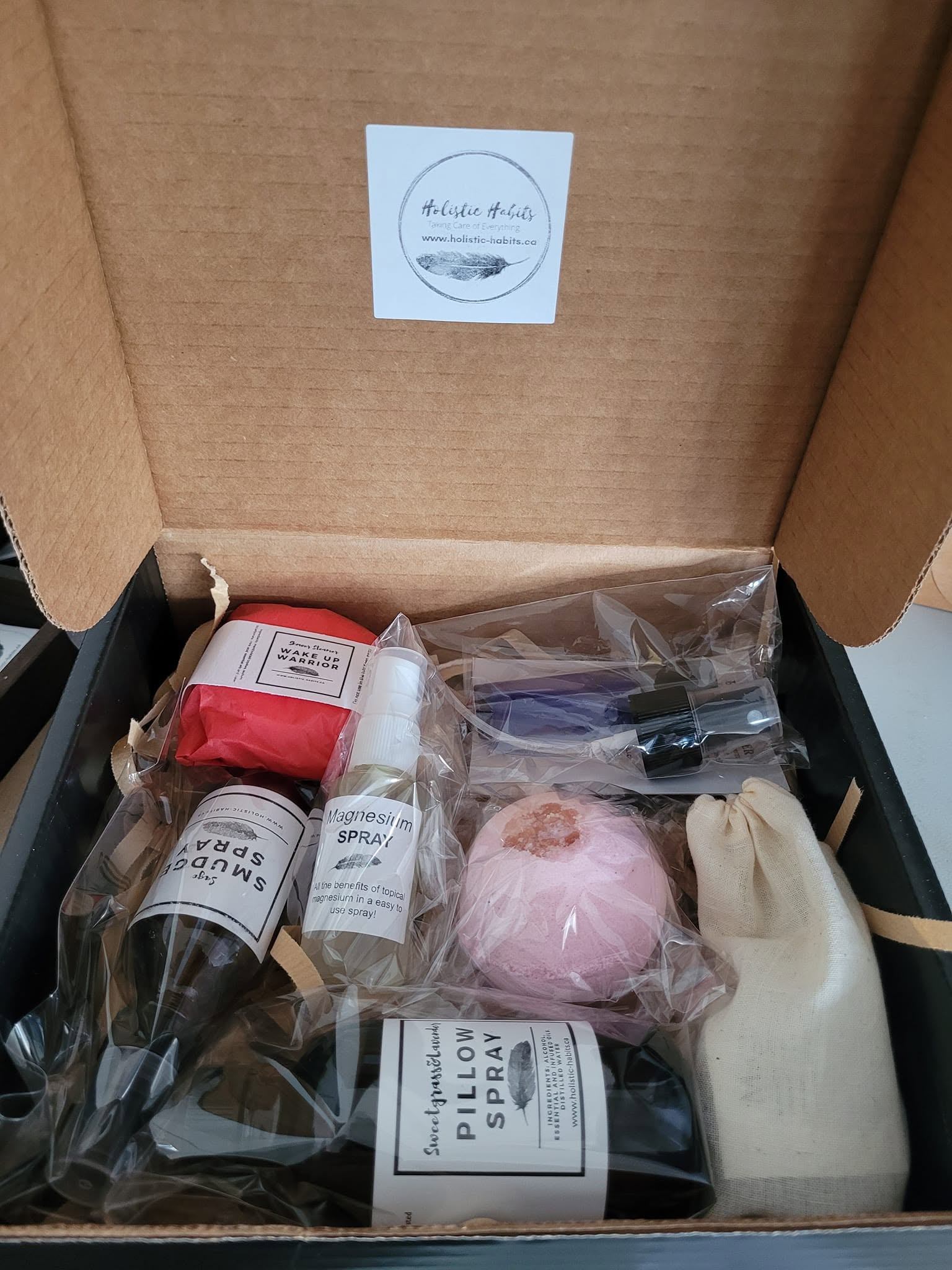 Open Holistic Habits gift box with sprays, bath bomb and small wellness items.