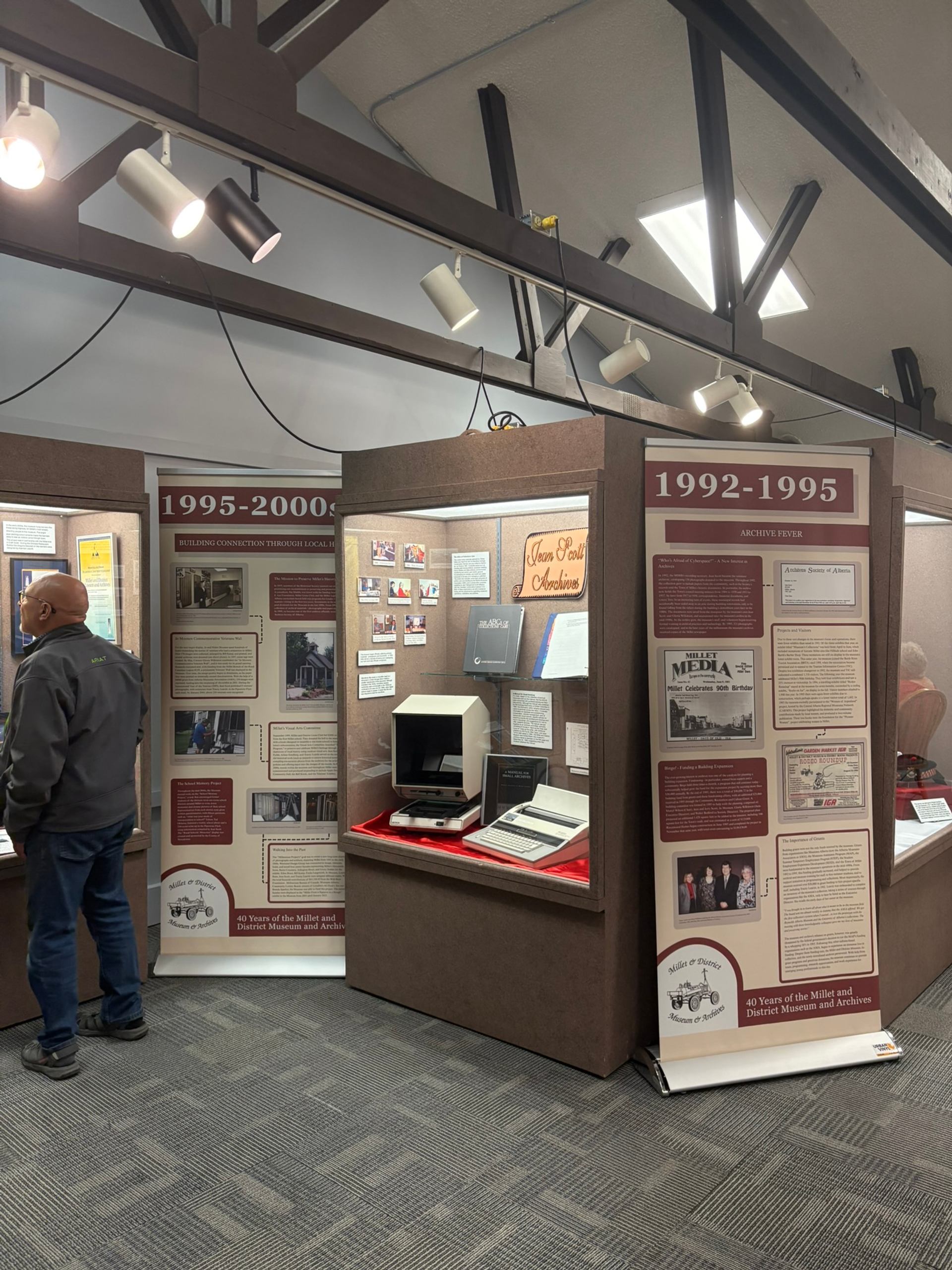 Indoor exhibit at Millet Museum featuring historical panels and artifacts from 1892–2000.