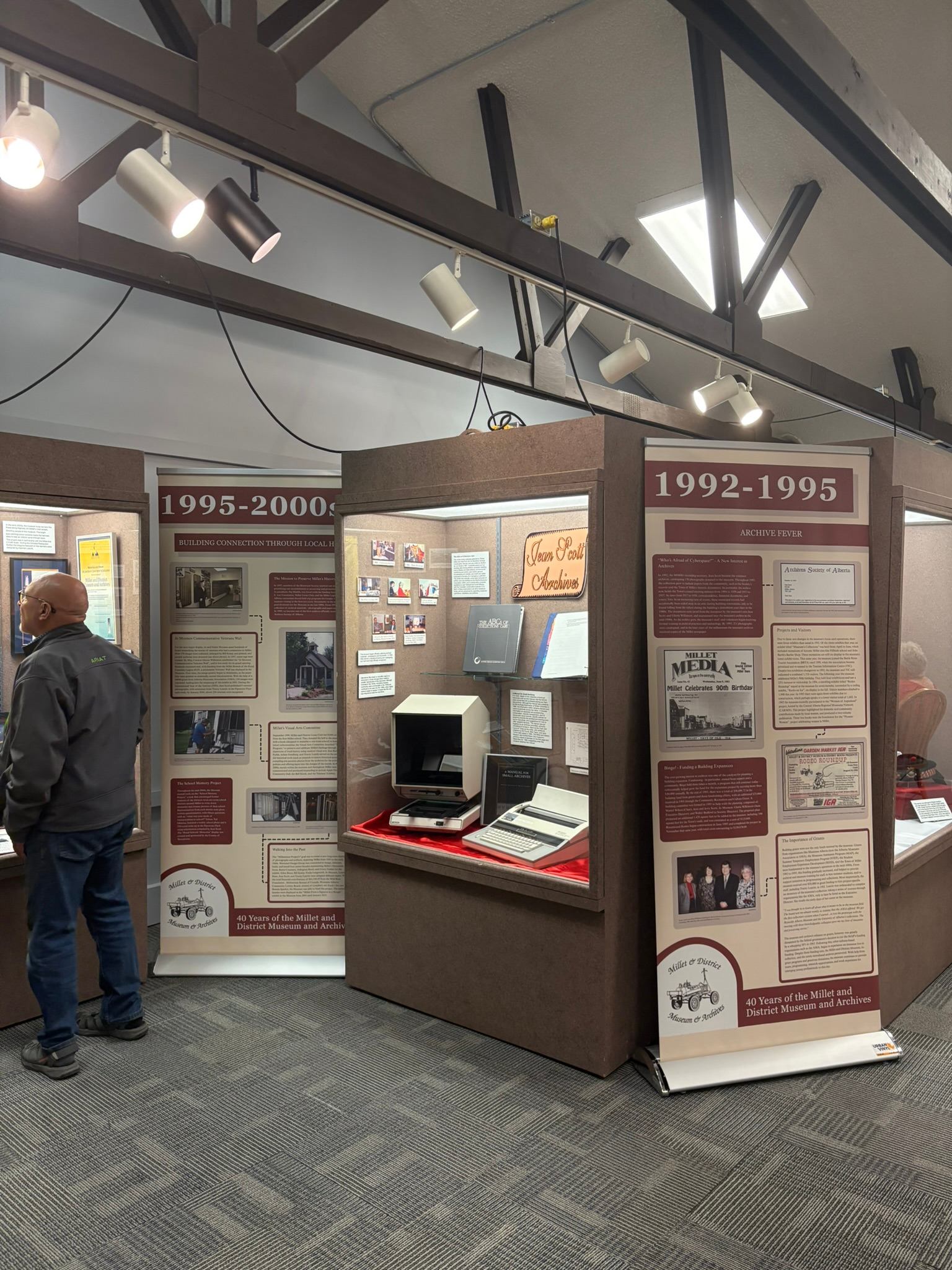 Indoor exhibit at Millet Museum featuring historical panels and artifacts from 1892–2000.