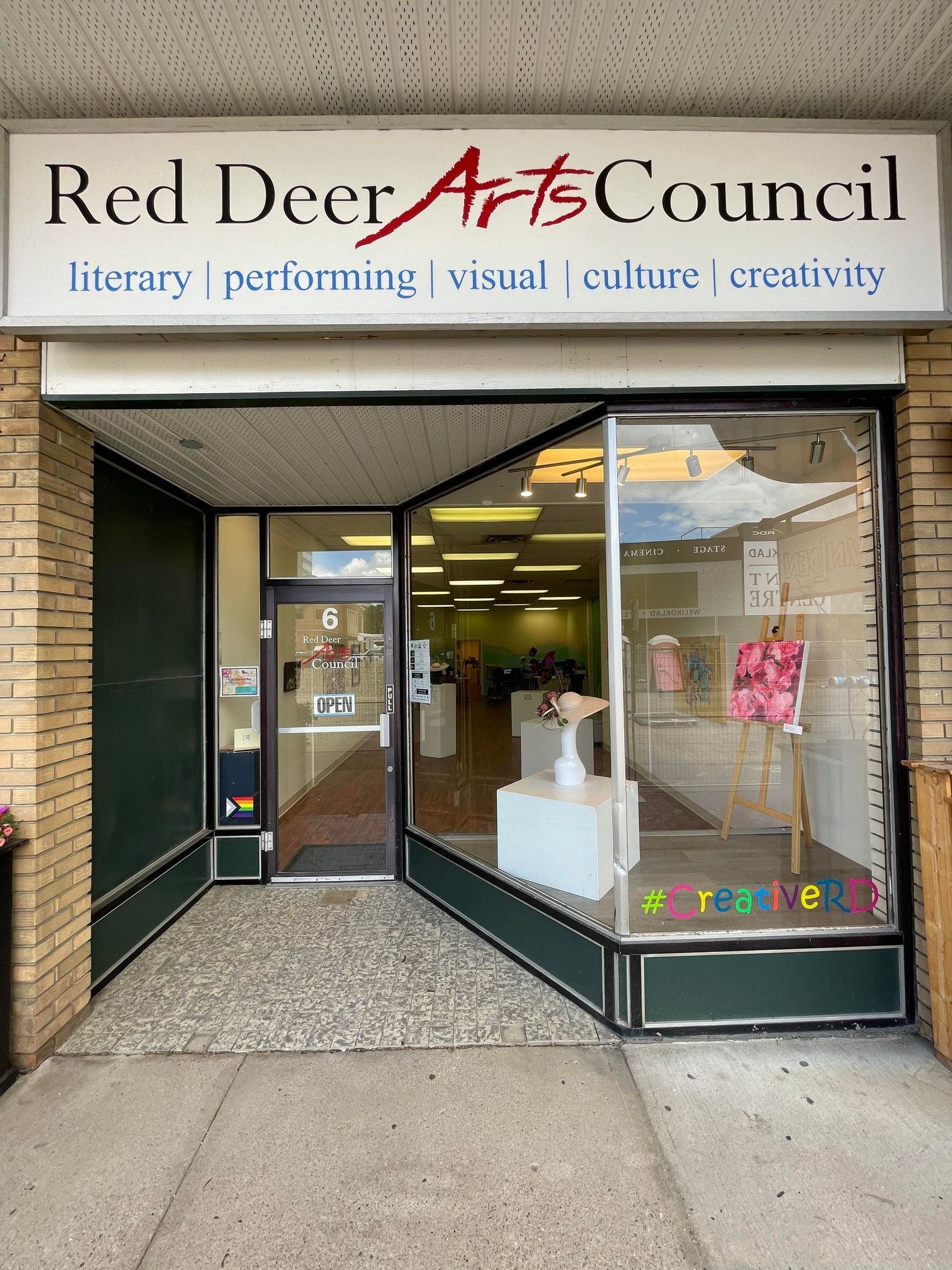Storefront of the Red Deer Arts Council with art in the windows.