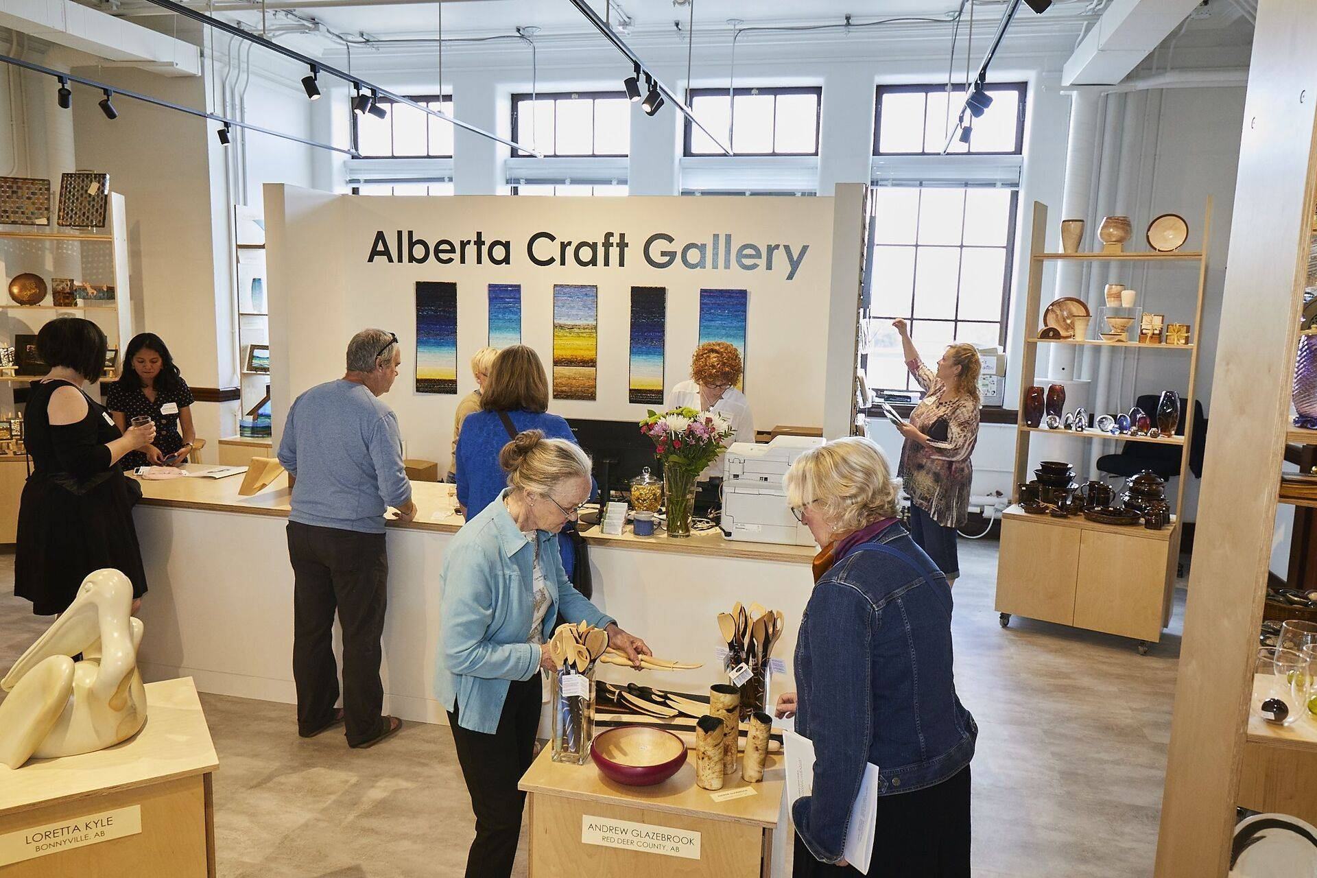 Visitors browse wooden utensils and pottery inside the Alberta Craft Gallery shop.