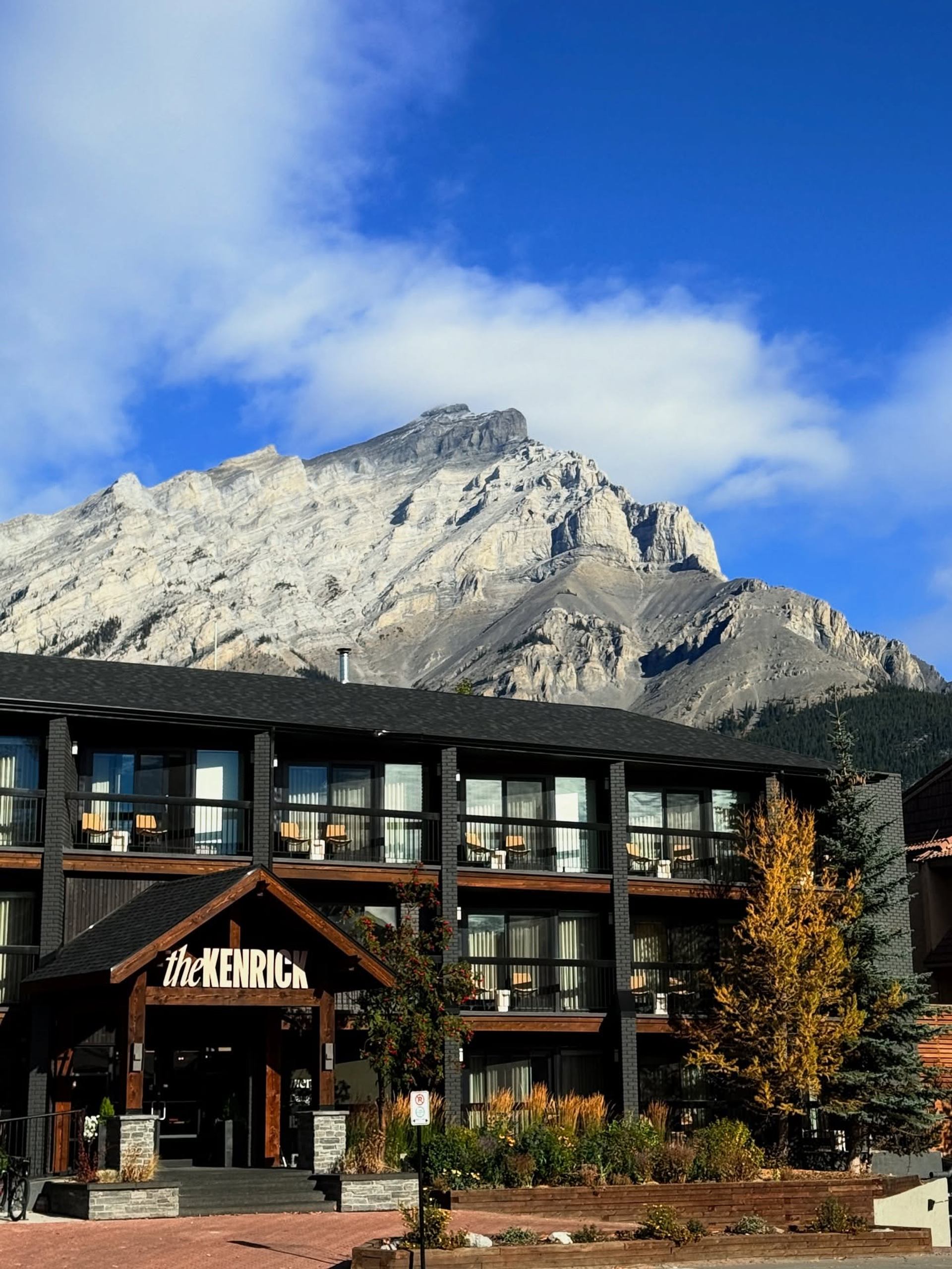 Kenrick Hotel exterior with balconies and mountain backdrop.