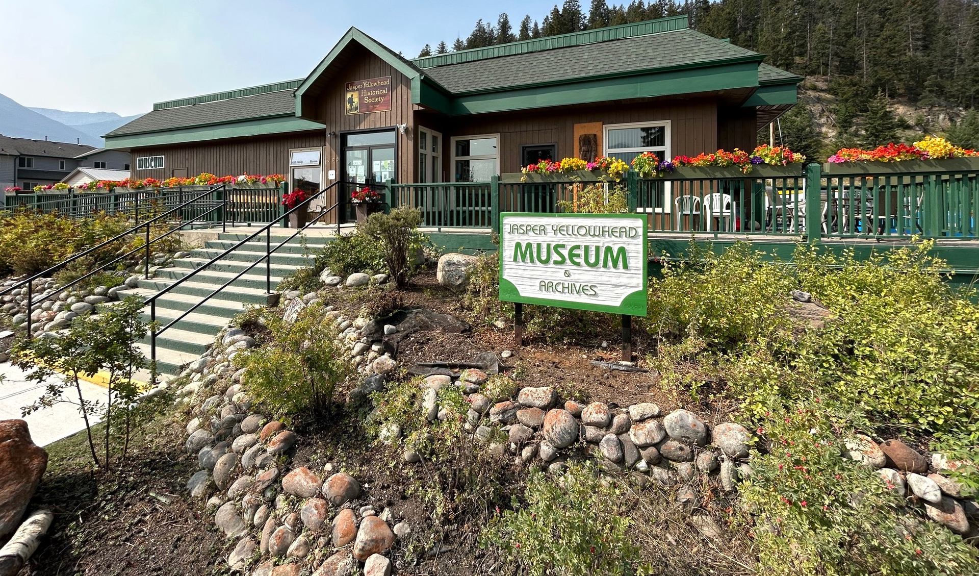 Jasper Yellowhead Museum and Archives building with green railings, flowers and stone landscaping.