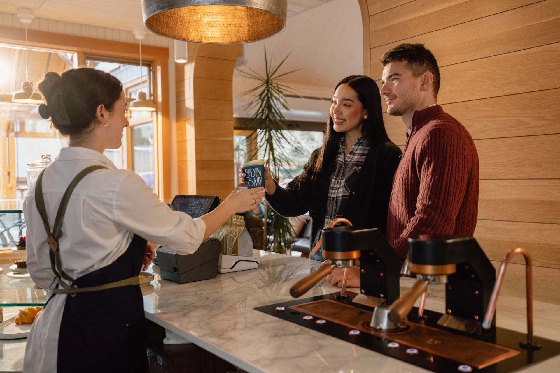 Couple being handed their to go coffees in the Sudden Sally cafe