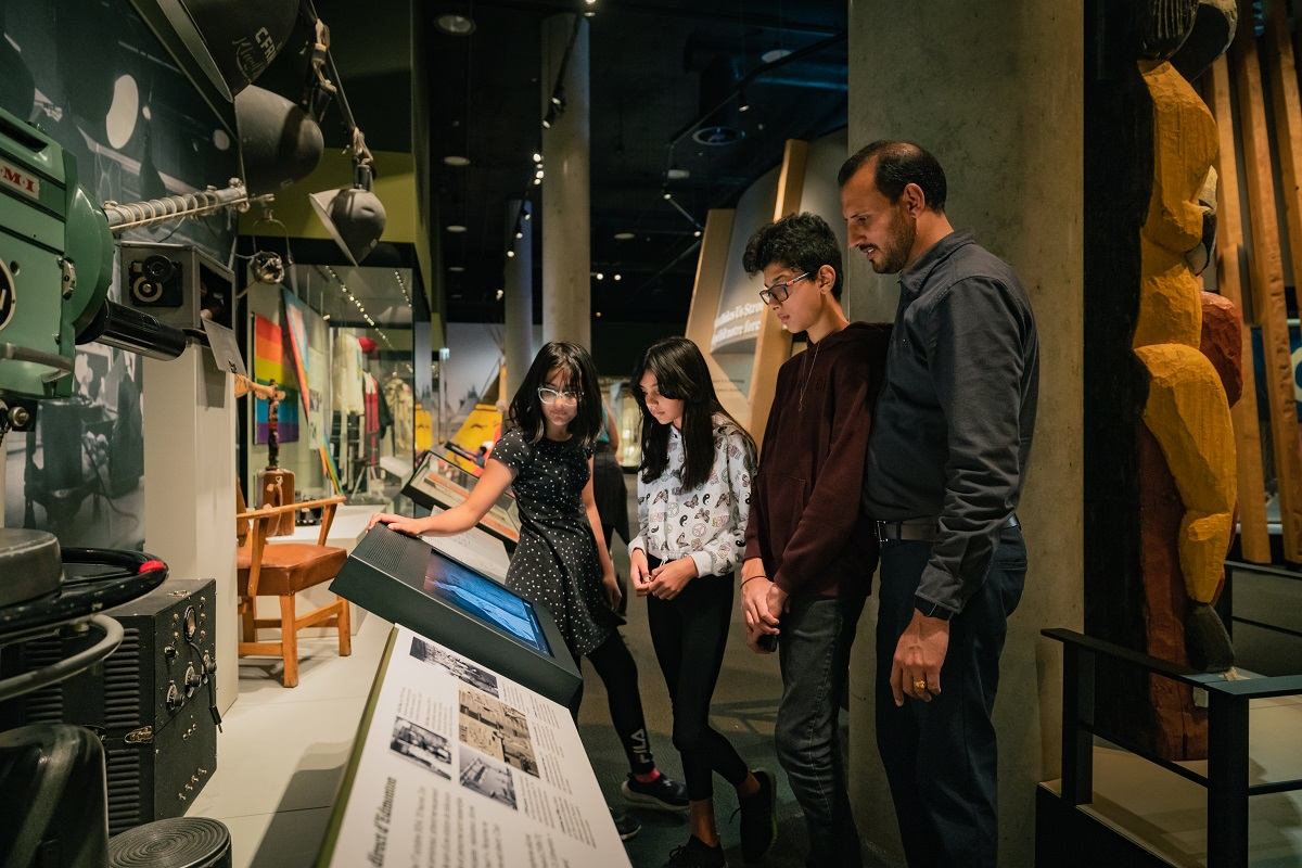 Museum visitors look at aviation display equipment and aircraft models inside an exhibit hall.