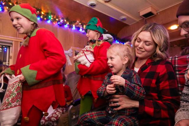 Family enjoying the Polar Express train ride while the elves go down the aisle