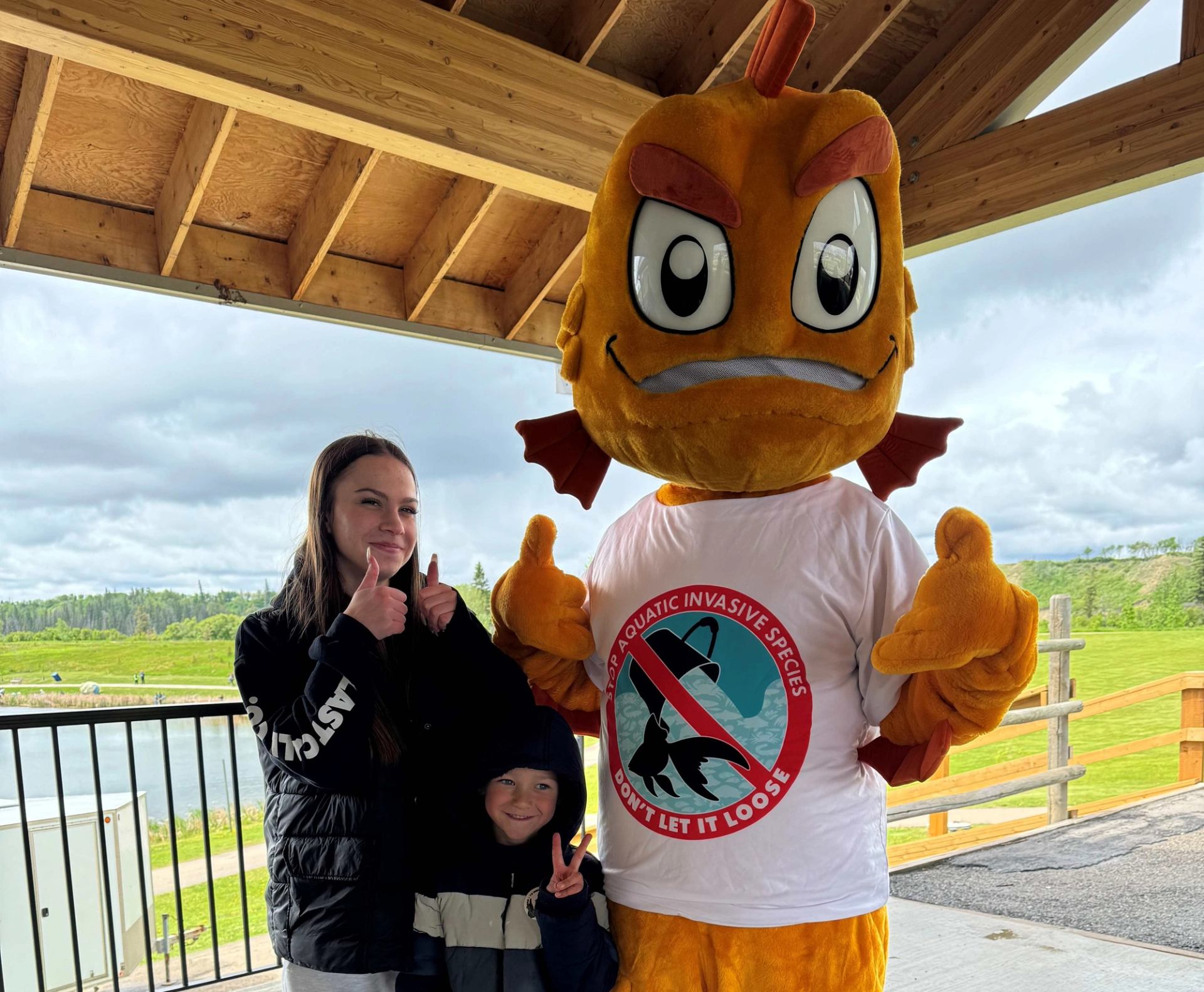 Tank the mascot with a person stood beside them with their thumbs up.