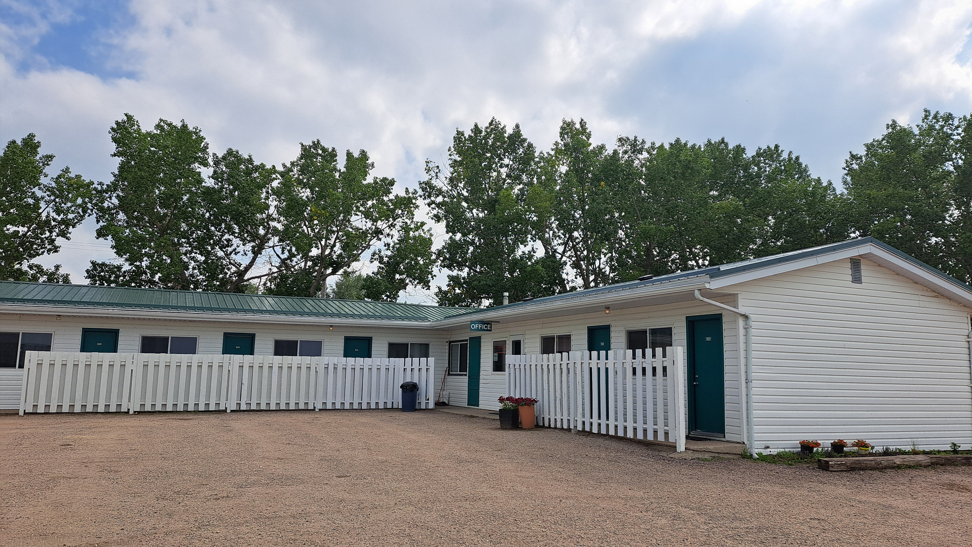 The Deerhead Inn exterior features guest rooms, white fencing, and mature trees surrounding the property.