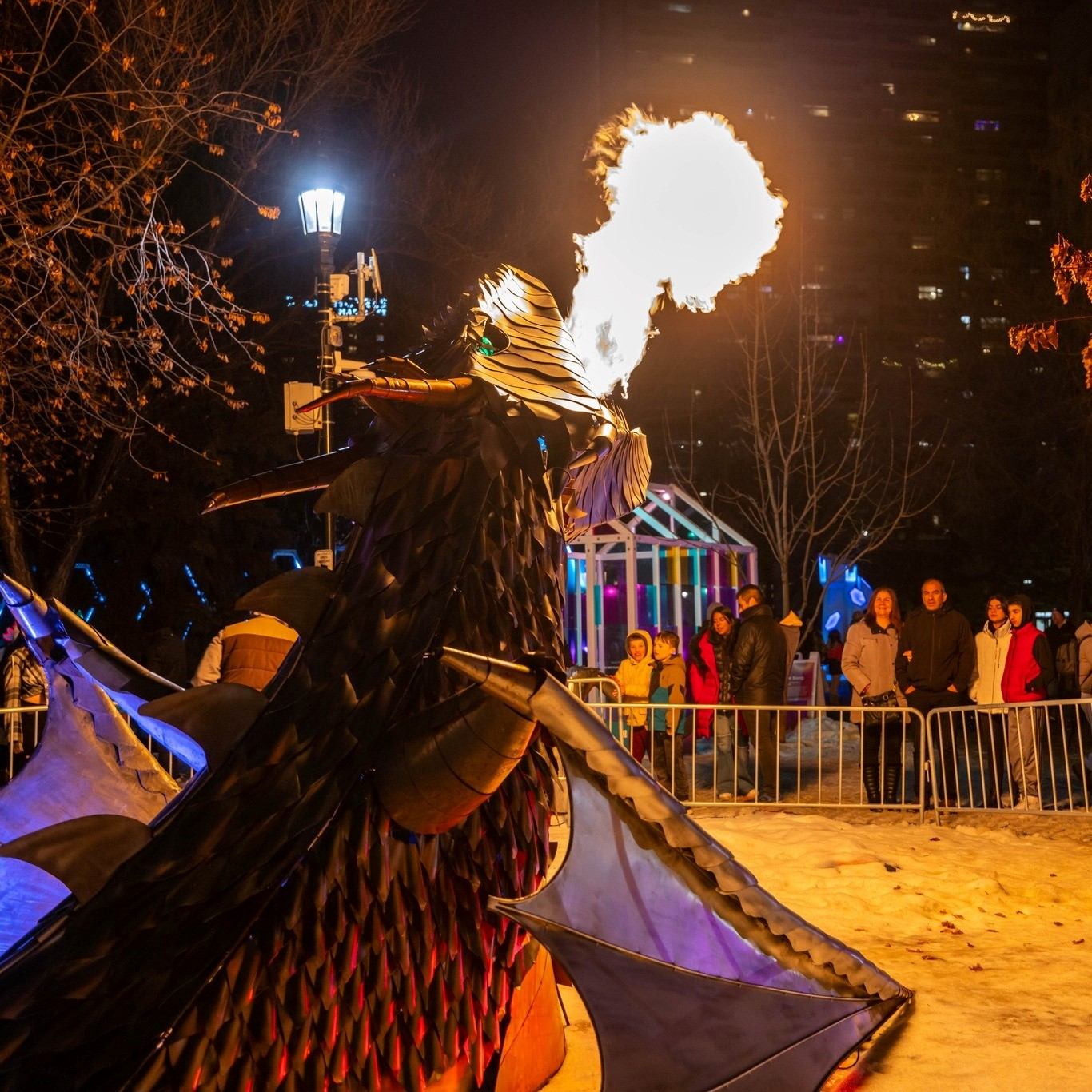 Fire shoots from dragon performer as crowd watches.