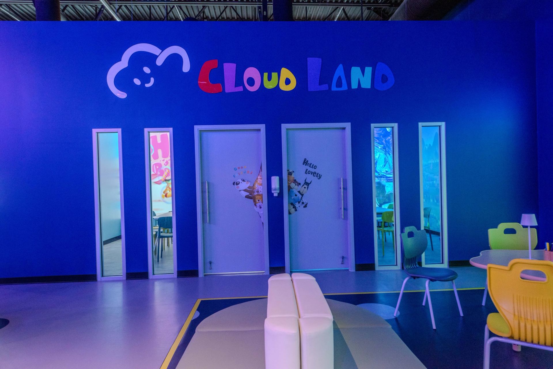 Cloud Land entrance with bright blue walls, colorful logo, and seating area.