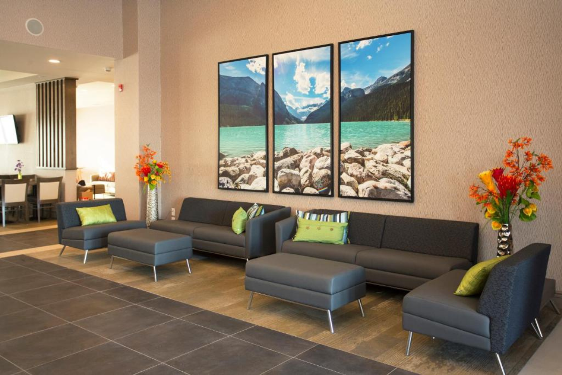Hotel lobby seating area with sofas, artwork, and decorative floral accents.