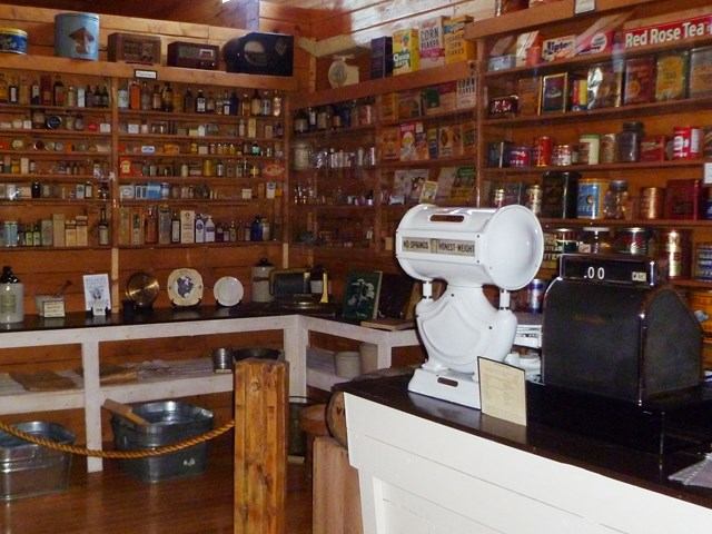 Vintage store with shelves of old goods, a scale, and a cash register.