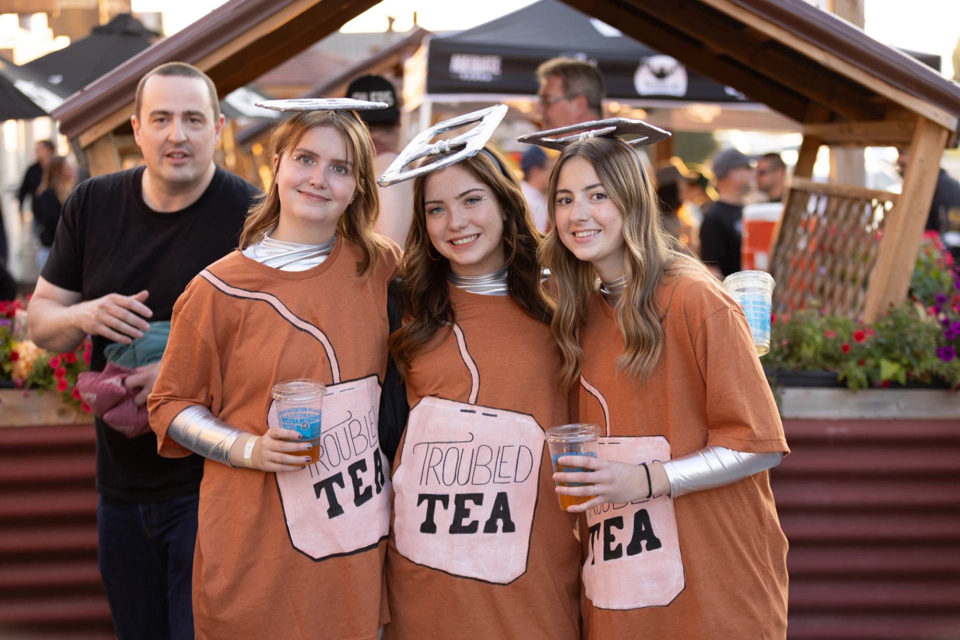 Three guests dressed as tea bags holding drinks at the anniversary celebration