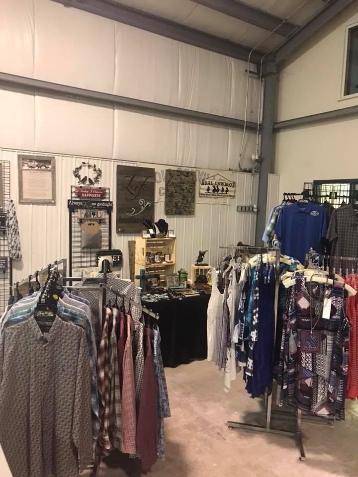 Western clothing racks and shirts inside a retail shop with framed wall decor.