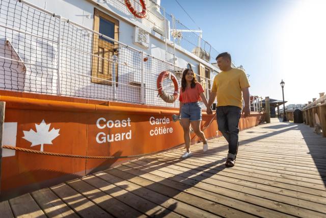 Couple walking down boardwalk at Fort McMurray Heritage Shipyard.