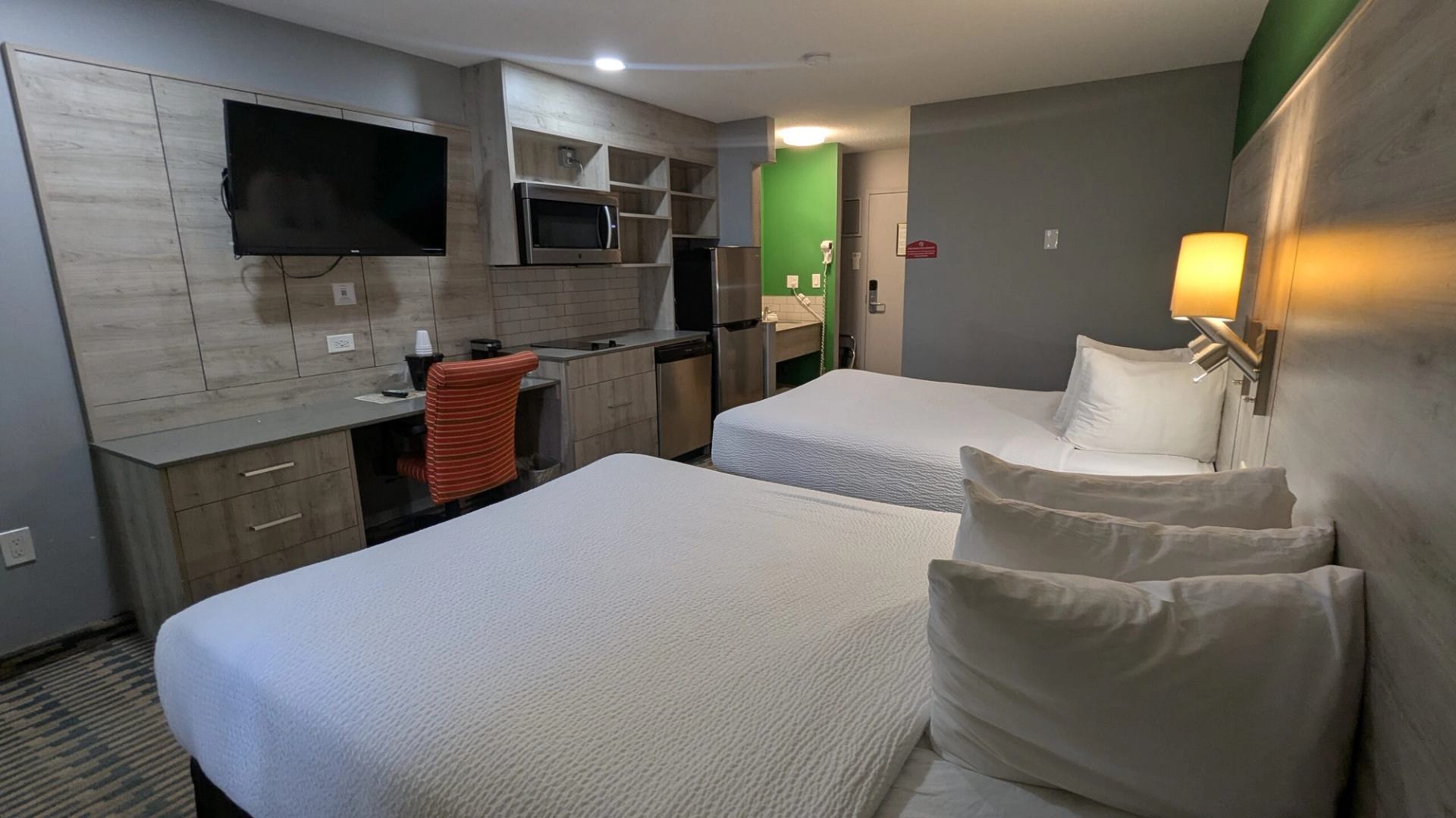 Modern hotel room with two beds, desk, TV, and amenities at Imperial Inn.