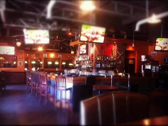 Grand Central Bar & Grill interior with bar stools and TV screens.