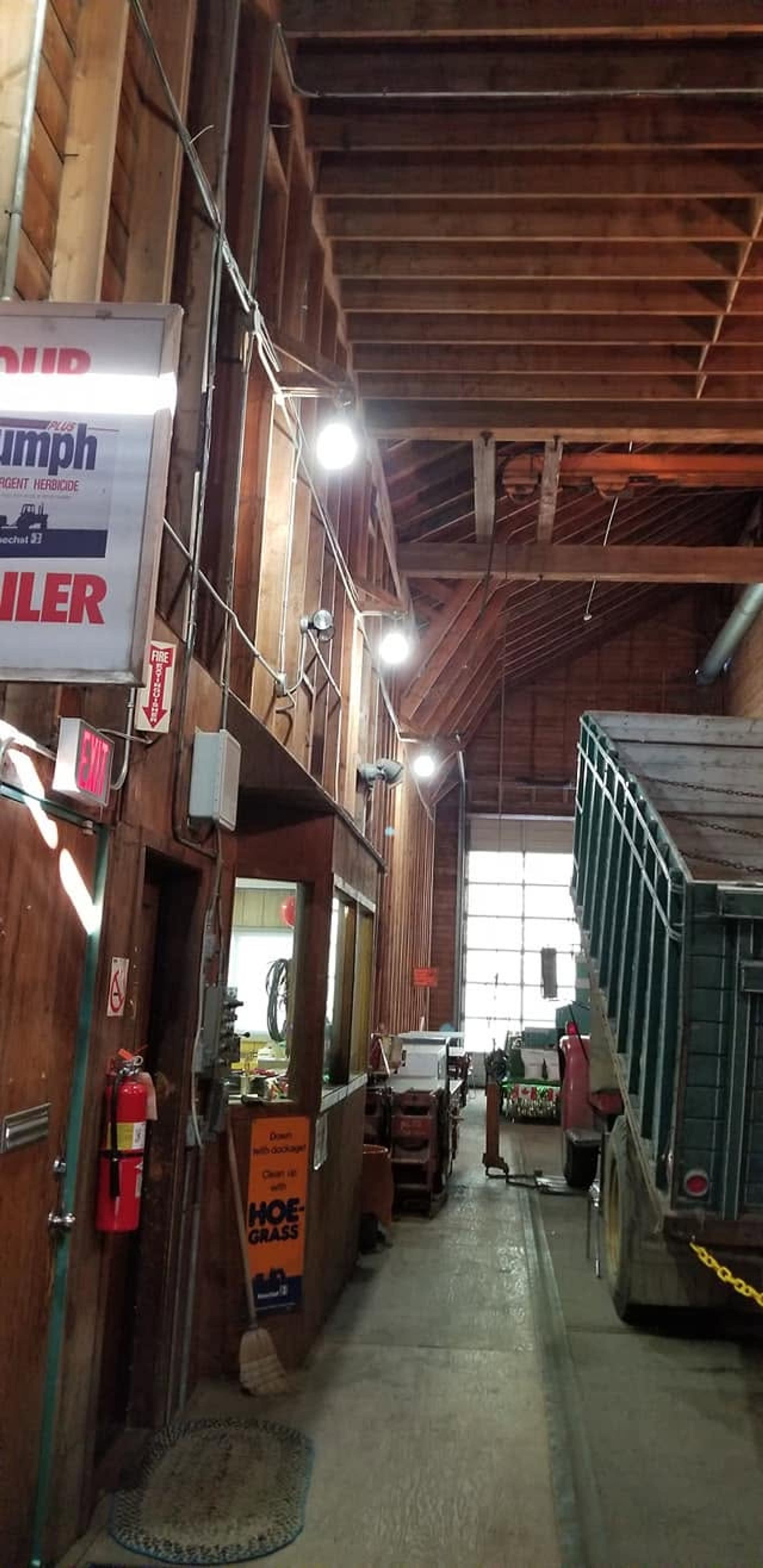 The interior of a historic grain elevator features wooden walls, vintage machinery, rail tracks, and farm equipment displays.
