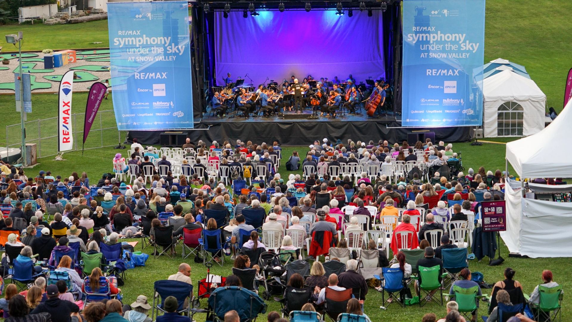 A crowd sat on the grass watching the Symphony