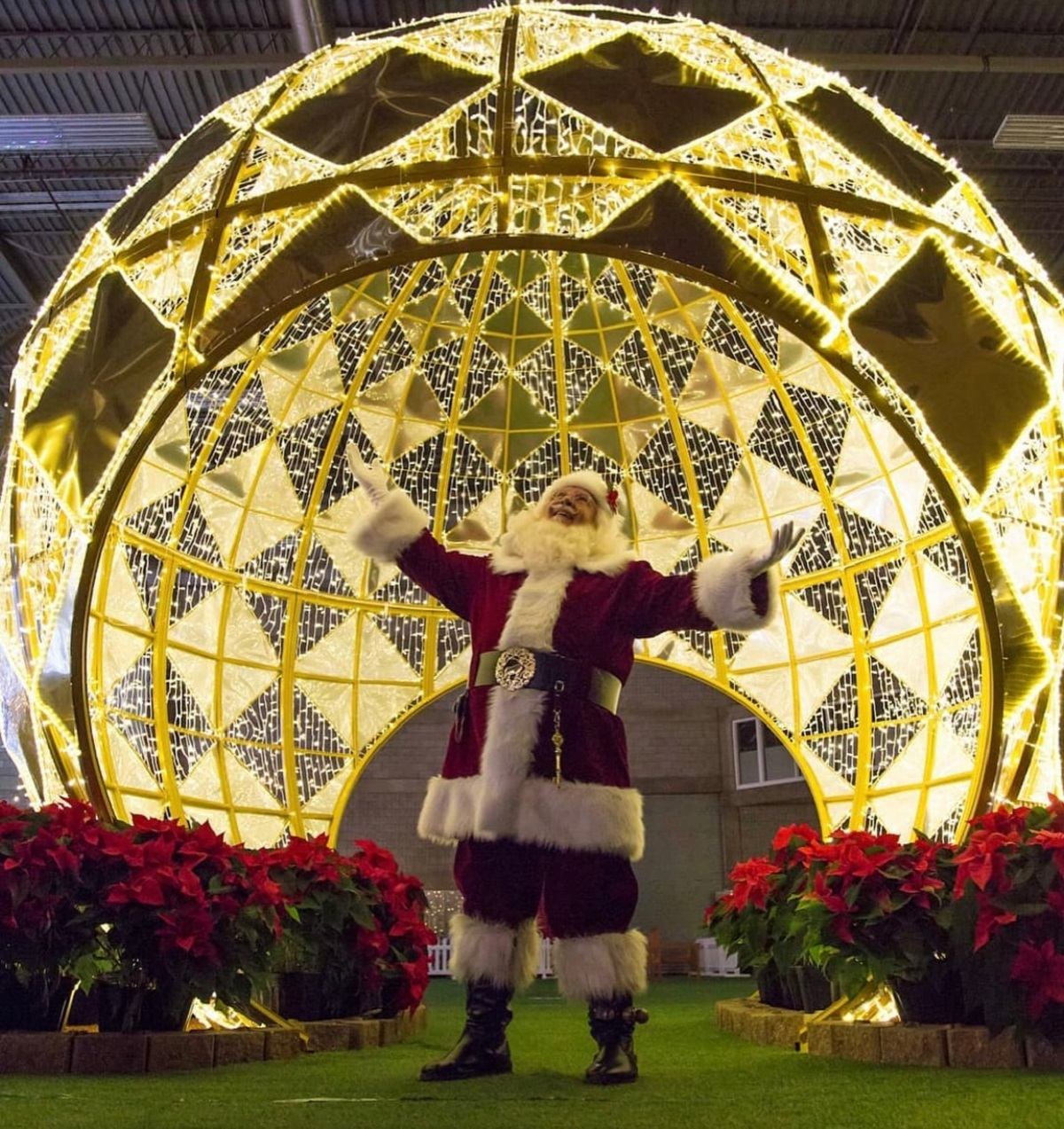 Santa stands under a glowing golden dome at Glow Calgary.