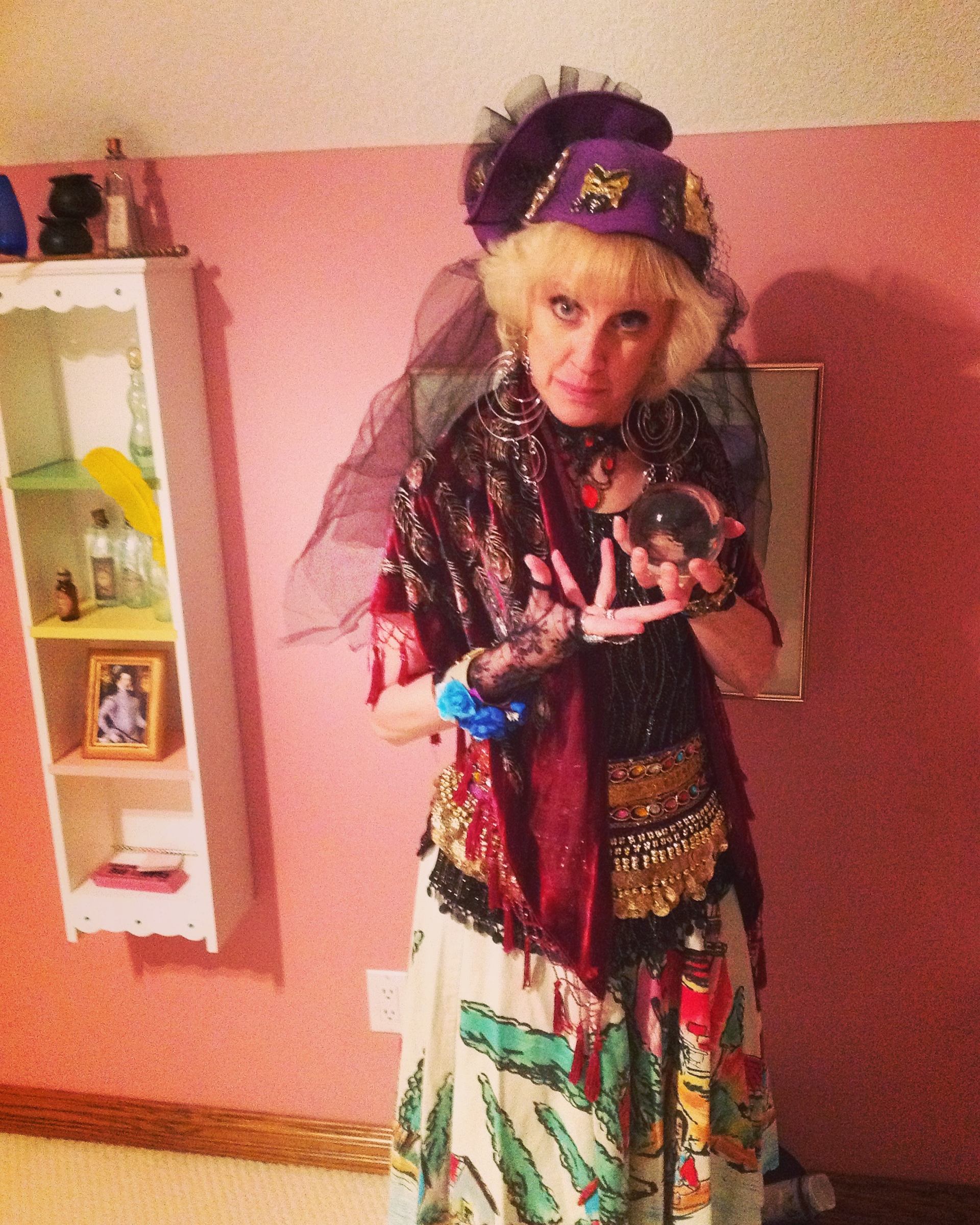 Person wearing a colorful fortune-teller costume with layered fabrics and accessories.