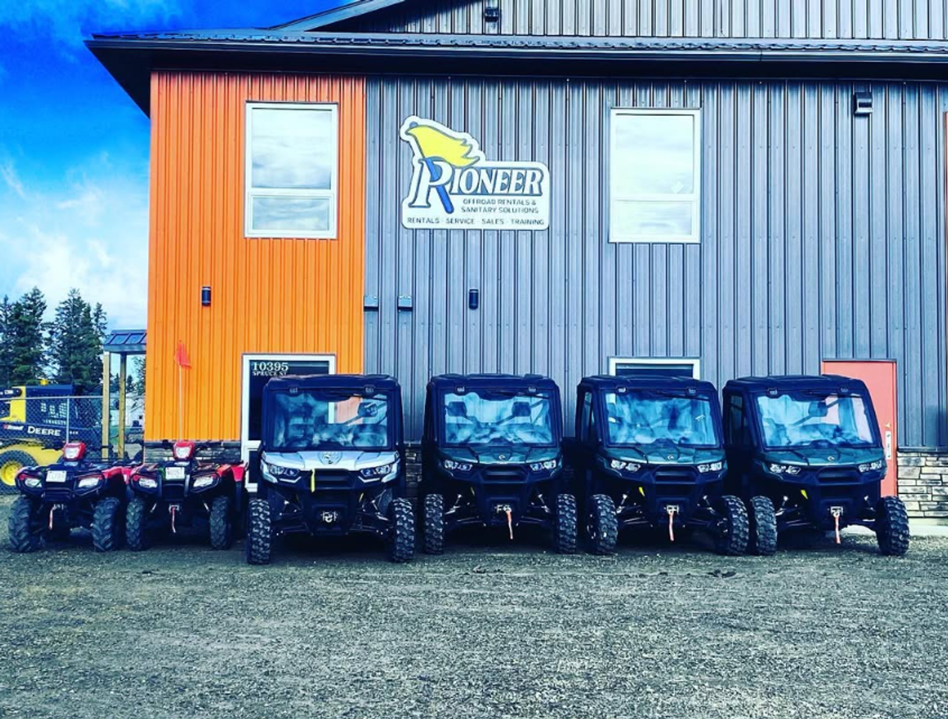 Row of ATVs and UTVs parked in front of Pioneer Offroad Rentals building