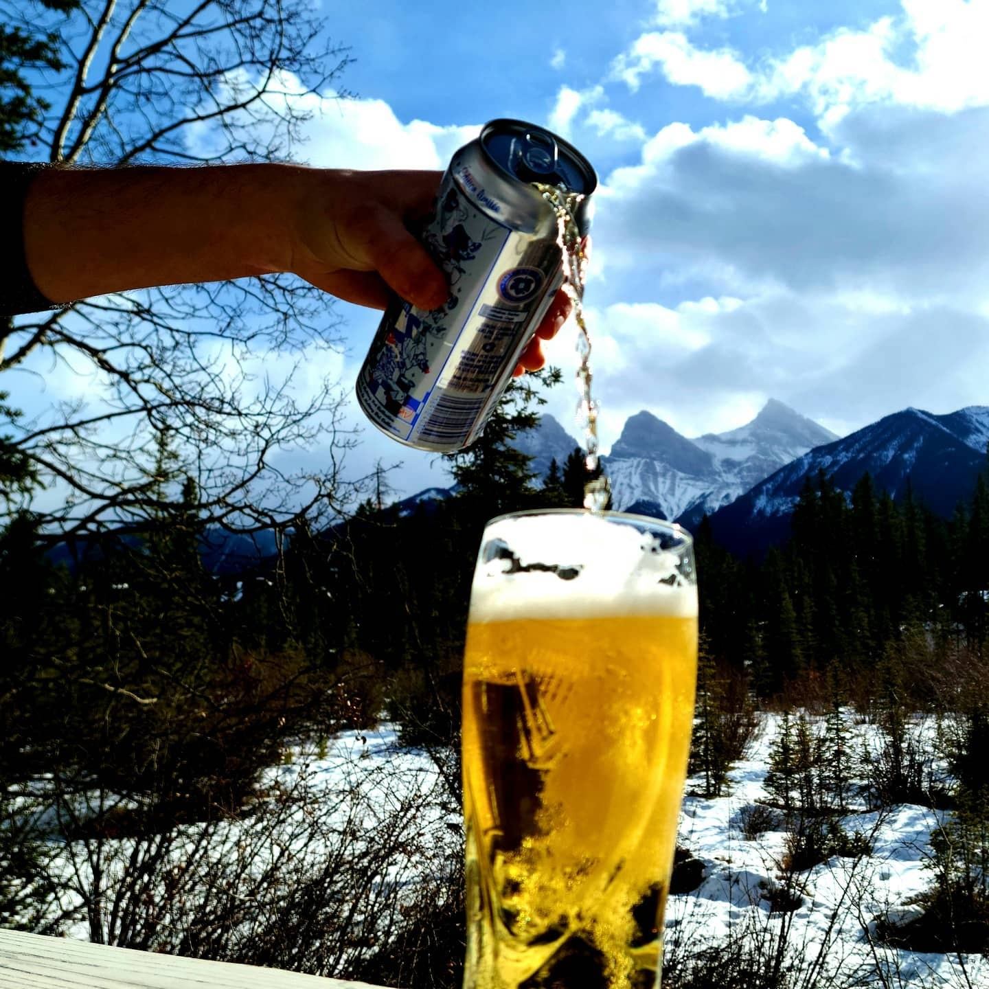 Pouring beer with snowy mountain views in the background.