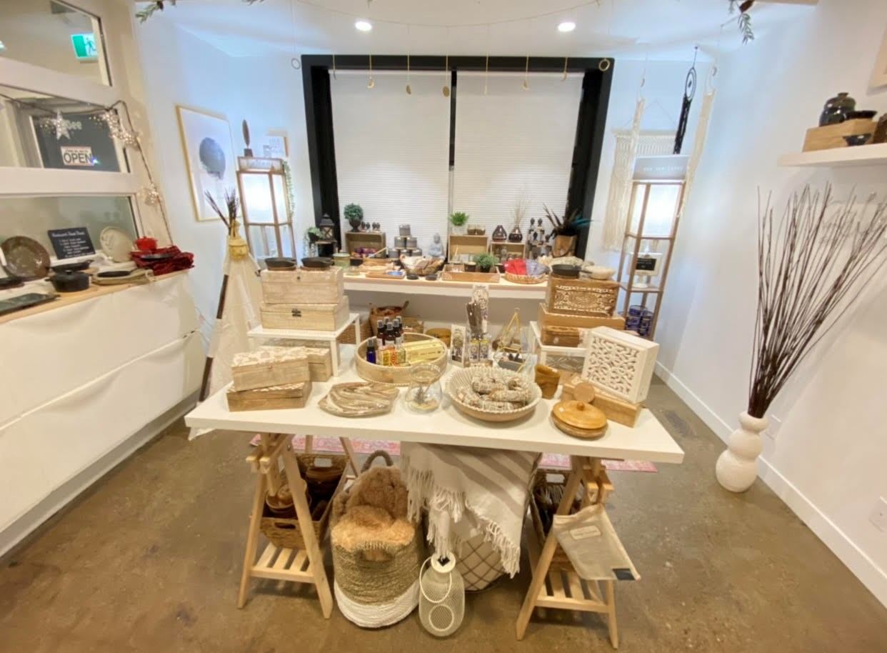 Retail display table with crafts and decorative home accessories inside a boutique store.