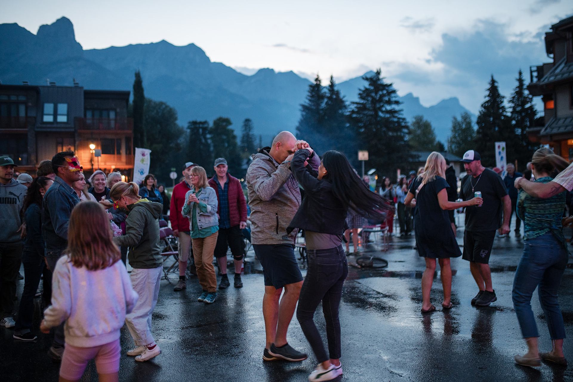 A couple dances in the street surrounded by people.