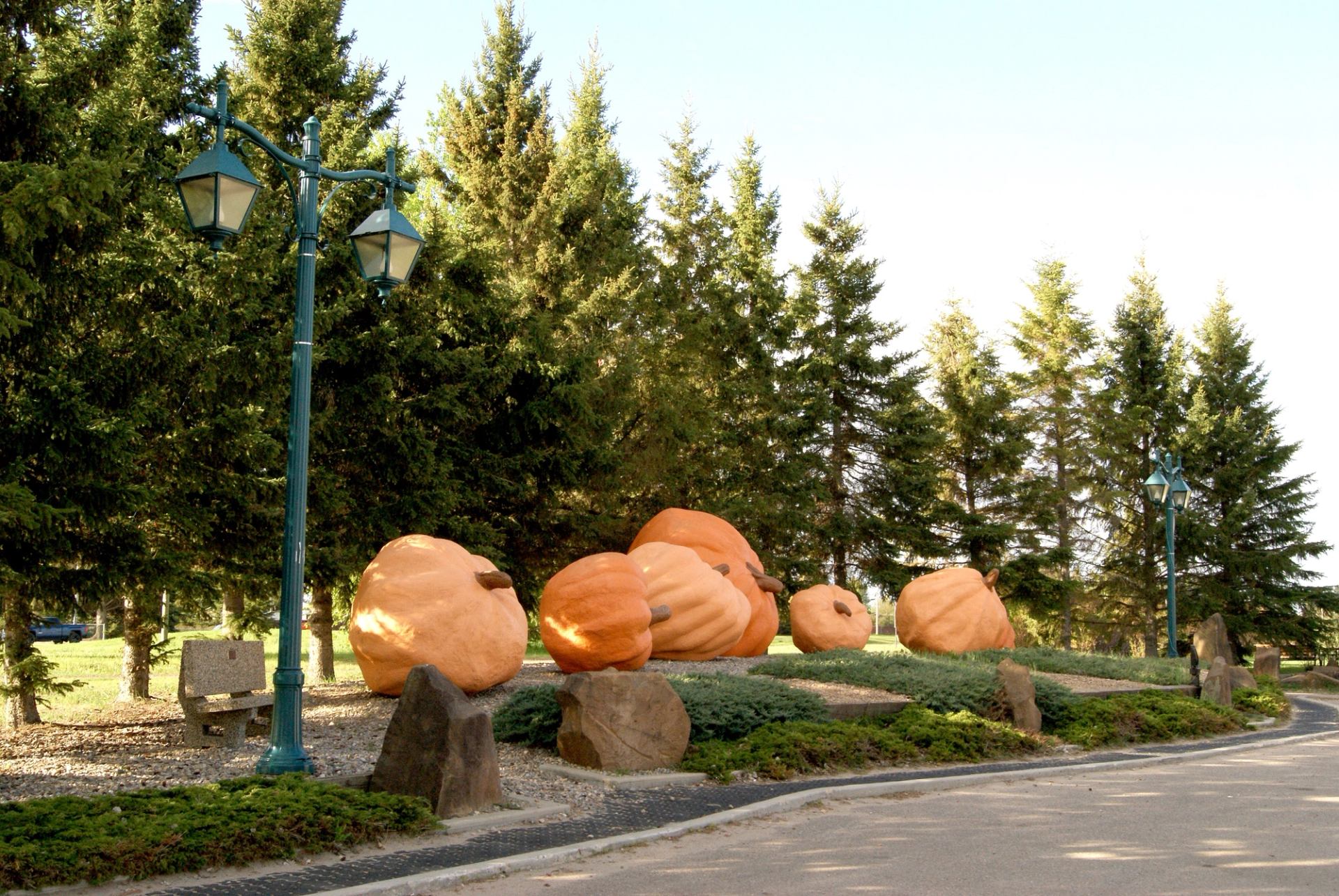 Enormous pale orange pumpkin on display pallet with two small yellow gourds beside it at fair.