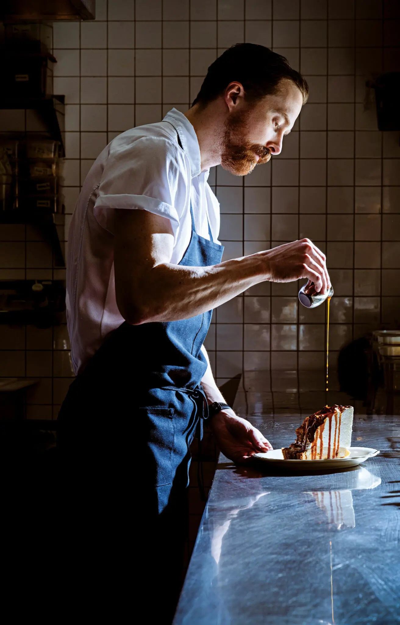 The chef adding sauce to dessert.