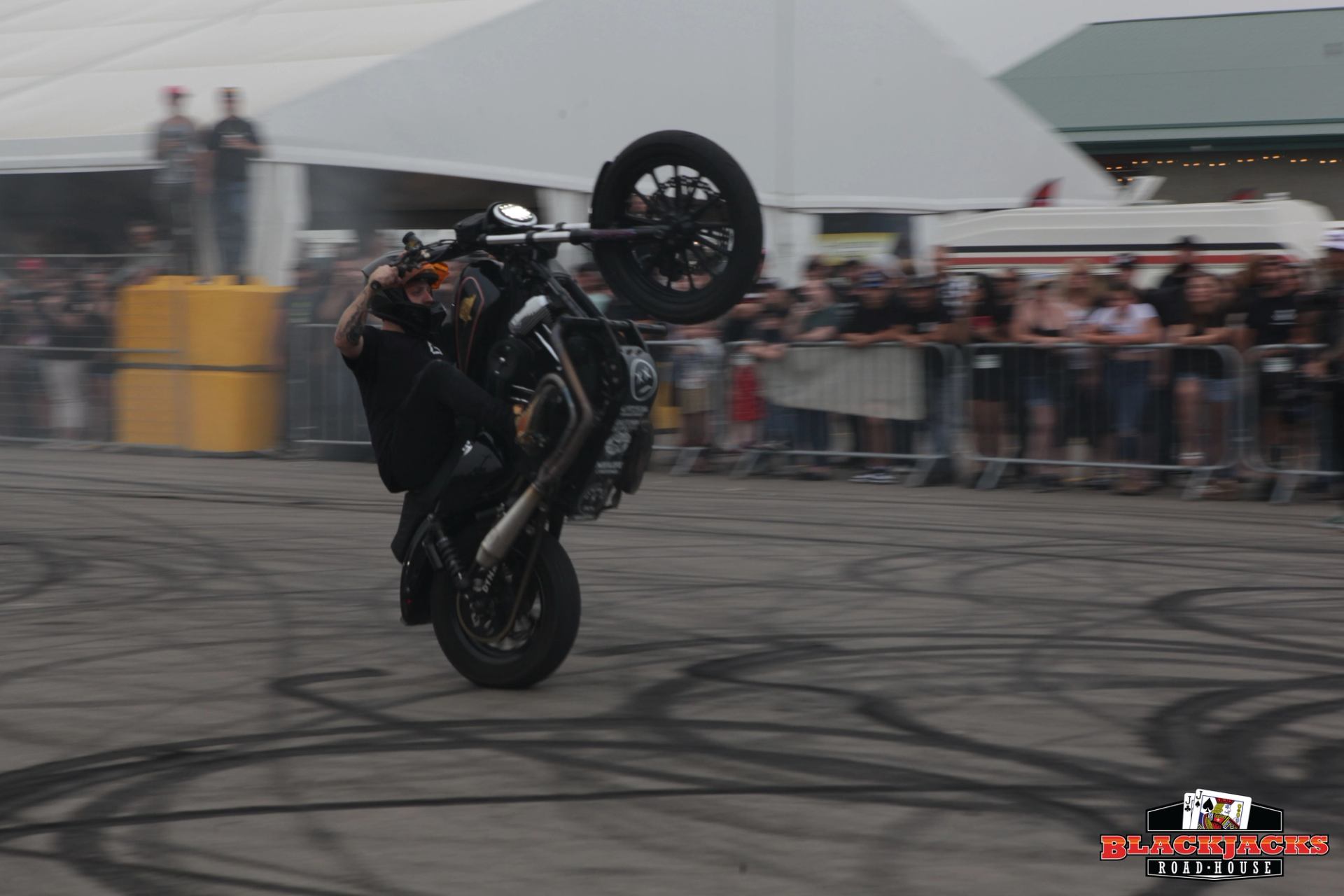 A biker doing a wheeling at Blackjacks parking lot.