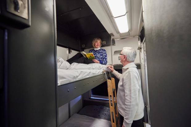 Couple preparing for overnight stay in cabin on VIA Rail train.