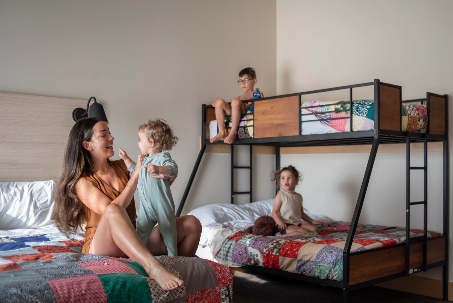 Double bed and bunk bed with patchwork quilts in a warm room at Métis Crossing Lodge.