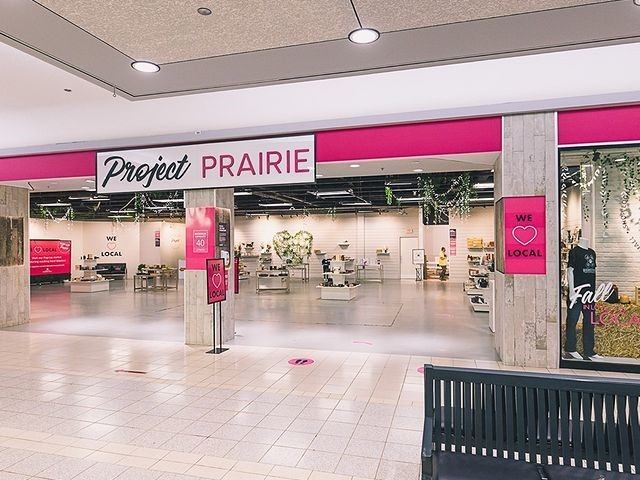 Entrance to Project PRAIRIE store with bright signage and local shopping displays.