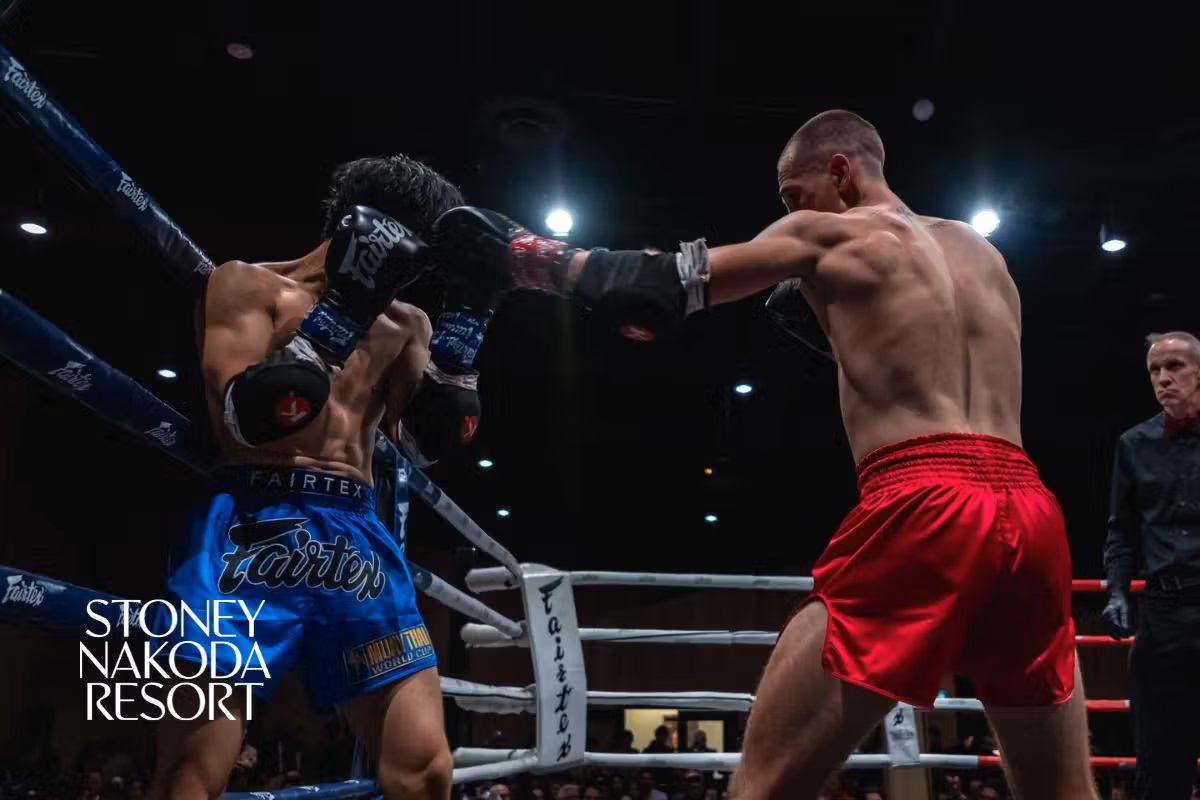 Two male fighters in a boxing ring, one throwing a punch and the other blocking.