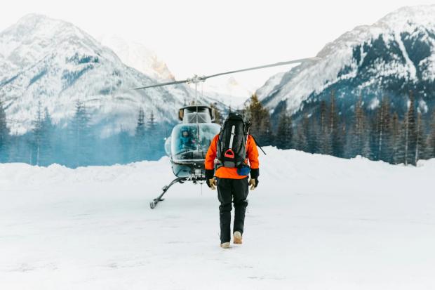 Man walking towards a helicopter after snowshoeing