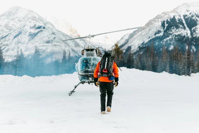 Man walking towards a helicopter after snowshoeing