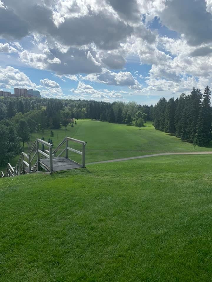 Fairway with wooden steps and surrounding trees under a cloudy sky at Victoria Golf Course.