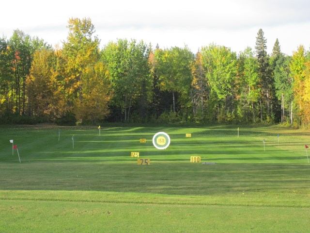 Golf course fairway with flags, yardage markers, and trees in the background at Gilwood Golf and Cou.