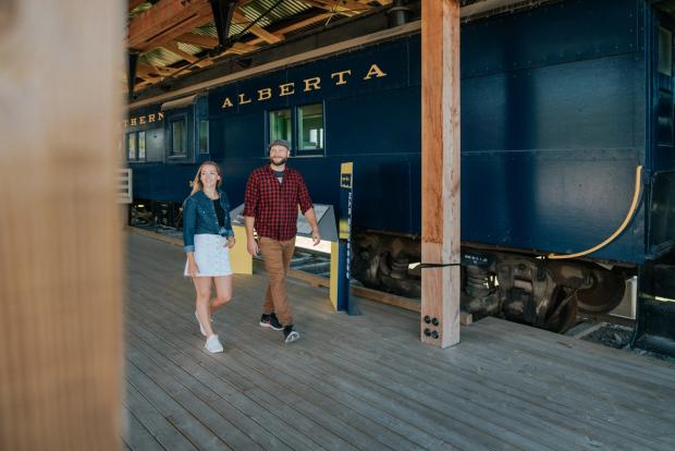 Couple walks near train at Heritage Shipyard.