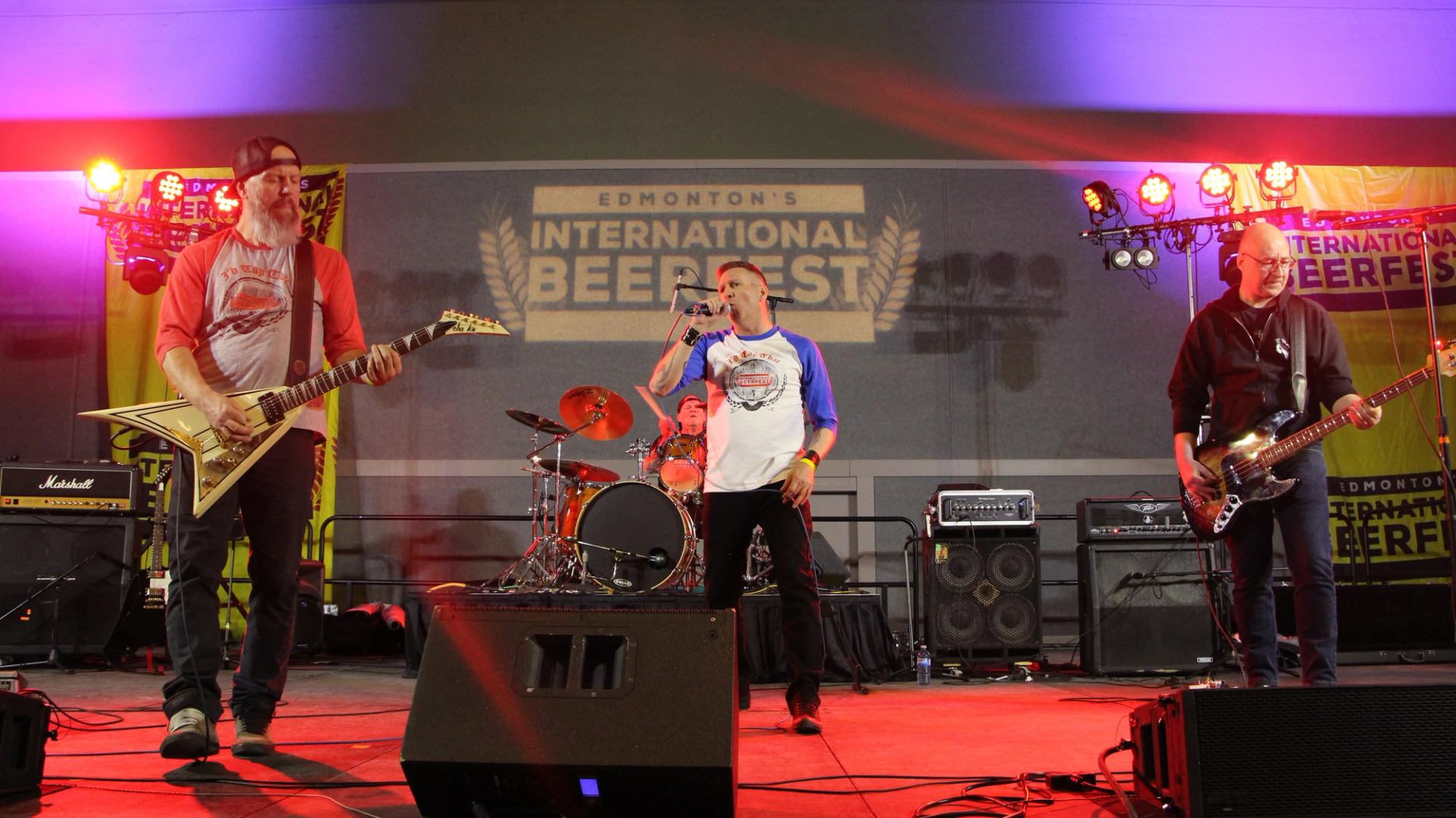 Rock band performing on stage at Edmonton’s International Beerfest under bright lights.